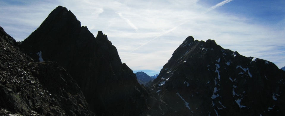 A jagged alpine ridge silhouetted against a bright sky.